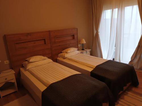 two beds in a hotel room with a window at Bucovina Lodge Pension in Vama