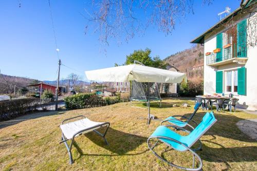 a pair of chairs and an umbrella in a yard at Mila Bike with wi-fi - Happy Rentals in Premeno