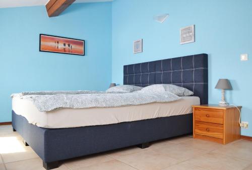 1 dormitorio azul con 1 cama con pared azul en Résidence Niccola, en Vidauban
