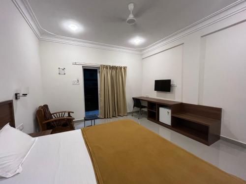 a bedroom with a bed and a desk and a television at Morjim Sunset Hotel in Morjim
