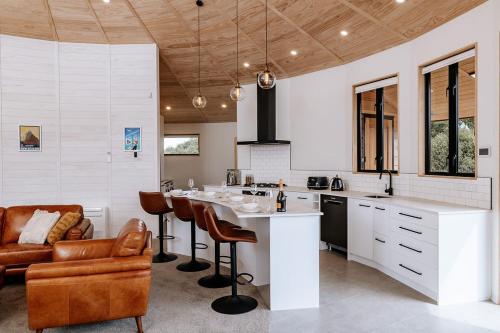 a kitchen with a table and chairs and a couch at Kaho - Ohakune Holiday Home with Spa in Ohakune