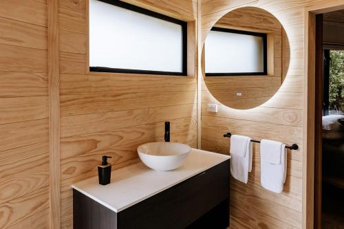 a bathroom with a bowl sink and a mirror at Kaho - Ohakune Holiday Home with Spa in Ohakune