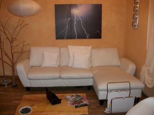 a living room with a white couch and a painting at La Loggia Di Federico in Navelli