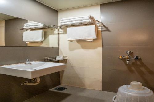 a bathroom with a sink and a mirror and a toilet at Hotel Royce Executive Near US Consulate, Bandra Kurla Complex in Mumbai