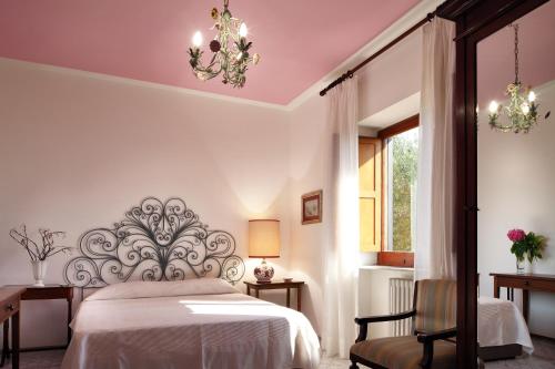 a bedroom with a bed and a chair and a window at M Suites Sorrento in Sorrento