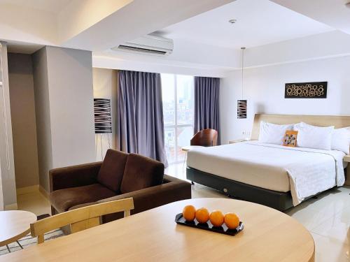 a hotel room with a bed and a table at Harper MT Haryono by ASTON in Jakarta