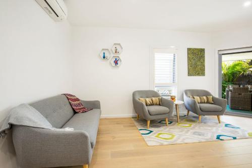 a living room with two chairs and a couch at Bowers Nest Pet Friendly 2 Mins Walk to Beach in Culburra Beach