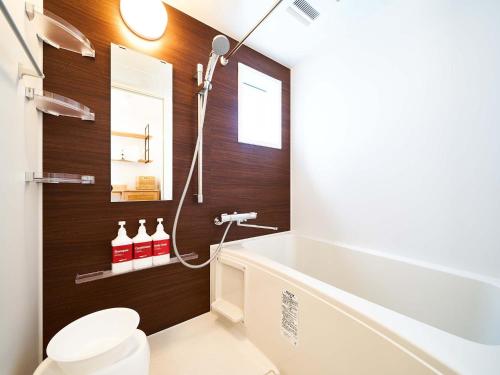 a bathroom with a tub and a toilet and a sink at Rakuten STAY HOUSE x WILL STYLE Saga Imari 101 in Imari