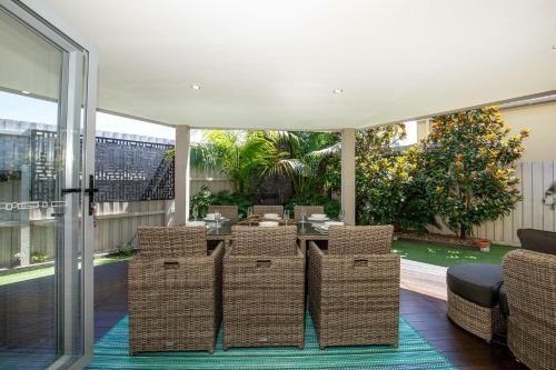 a dining room with wicker chairs and a table at Bowers Nest Pet Friendly 2 Mins Walk to Beach in Culburra Beach