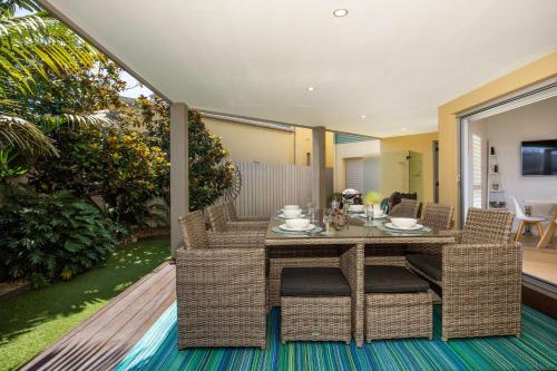 a dining room with a table and chairs on a patio at Bowers Nest Pet Friendly 2 Mins Walk to Beach in Culburra Beach
