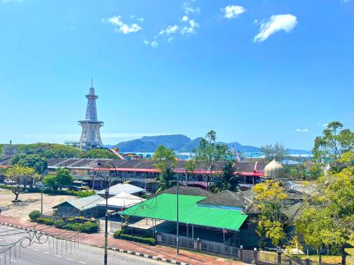 a building with a green roof with a lighthouse in the background at Citin Langkawi by Compass Hospitality in Kuah