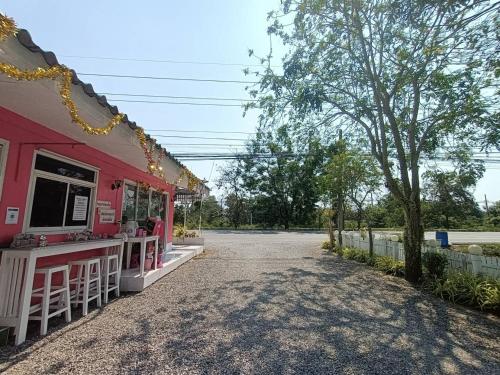 a pink restaurant with a counter on a street at Saan Rak Resort in Prachuap Khiri Khan