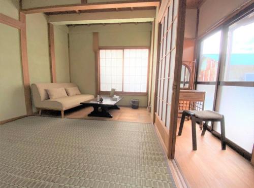 a living room with a couch and a table at 宿いちのみや in Ichinomiya