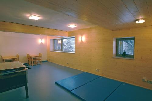 Zimmer mit Holzwänden, einem Tisch und Fenstern in der Unterkunft Chata H&D Červenohorské Sedlo in Kouty