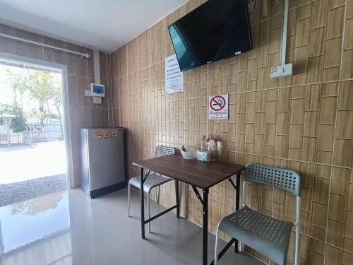 ein Esszimmer mit einem Tisch und Stühlen sowie einem TV in der Unterkunft Saan Rak Resort in Prachuap Khiri Khan