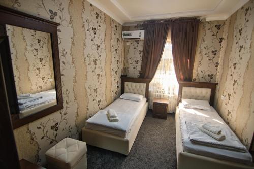 a small room with two beds and a mirror at BRICK PALACE in Samarkand