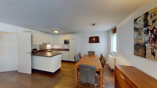 a kitchen and dining room with a table and chairs at Walensee House & Apartments in Unterterzen