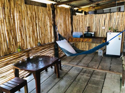 a hammock in a room with a refrigerator and a table at Navareeya House Seaview in Ko Lanta