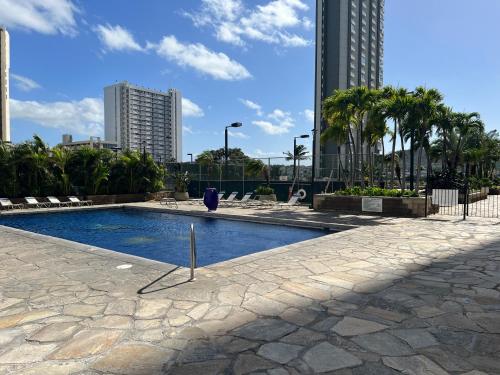 a swimming pool in a city with tall buildings at Waikiki Sunset Free Parking in Honolulu