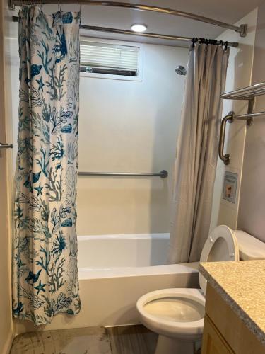 a bathroom with a toilet and a shower curtain at Waikiki Sunset in Honolulu