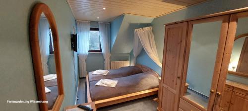 um pequeno quarto com uma cama e um espelho em Ferienwohnung Wiesenhang em Winterberg