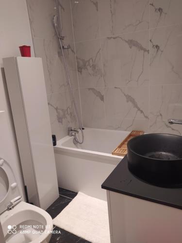 a bathroom with a toilet and a tub and a sink at Appartement moderne au centre de Paris in Paris