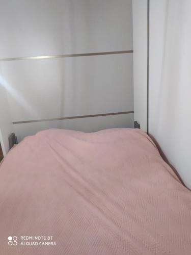 a bed with a pink blanket on top of it at Appartement moderne au centre de Paris in Paris