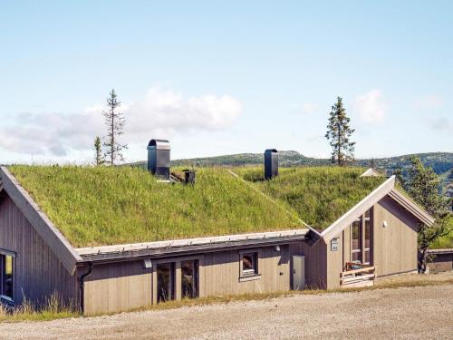 a grass roofed building with a building with a grass roof at 10 person holiday home in F vang in Favang