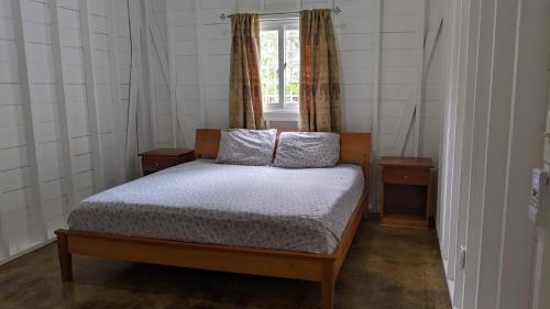 a bedroom with a bed with two pillows and a window at Big Creek Casita in Bocas del Toro