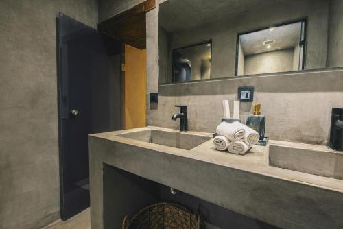 y baño con lavabo y toallas. en Oniros Residenza Vecchia, en La Canea