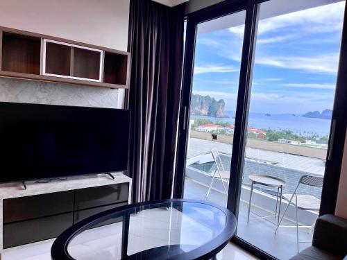 sala de estar con mesa de cristal y ventana grande en A402-Silk Condo Aonang-Sea view-5 mins walk to beach, en Ao Nang Beach