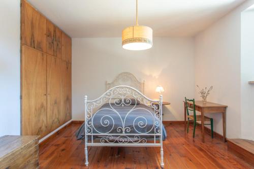 uma cama branca num quarto com uma mesa em Dimora Pietre Verdi em Cosentino