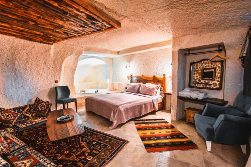 a bedroom with a bed and a chair in a room at APEX CAVE HOTEL in Goreme