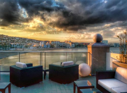 a balcony with couches and a view of a city at Hotel Boutique La Mar - Adults Only in Peñíscola