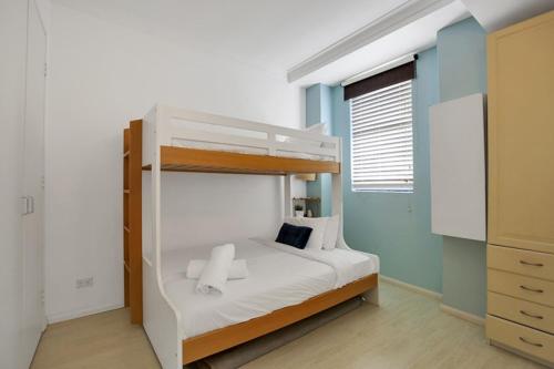 um quarto com um beliche com lençóis brancos em Apartment at Cooper St em Sydney