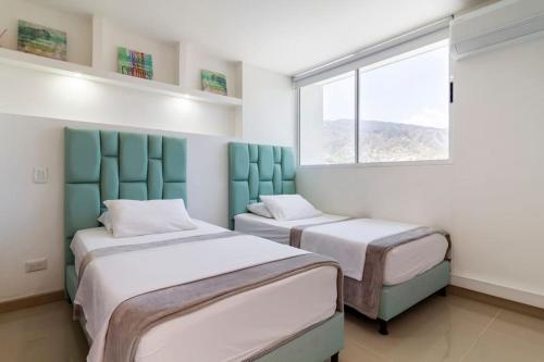 Duas camas num quarto com uma janela em Apartamento Citadela Di Sole Santa Fe Antioquia em Santa Fe de Antioquia