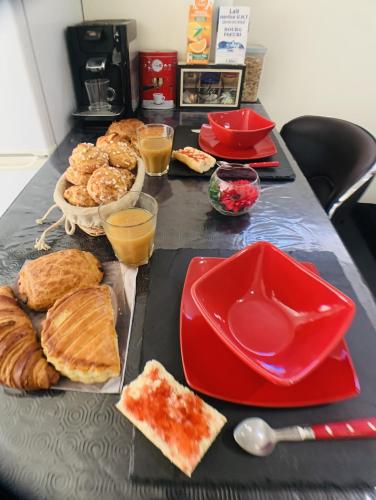 une table recouverte de assiettes rouges et de bols de nourriture dans l'établissement Appartement cosy proche Roissy CDG Astérix DisneyLand Paris, à Goussainville