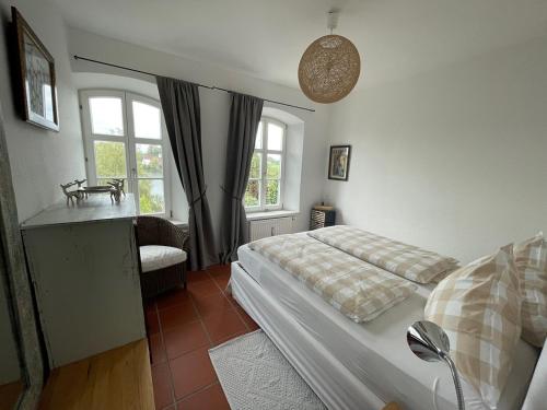 1 dormitorio con 1 cama, 1 silla y ventanas en Haus am Weinberg, 83370 Seeon Oberbayern, en Seeon-Seebruck