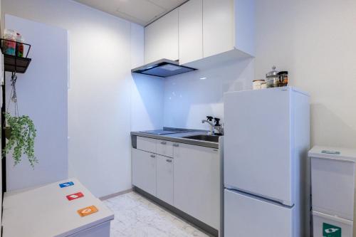 a kitchen with a white refrigerator and a sink at Southerlies Condominium Onna in Onna