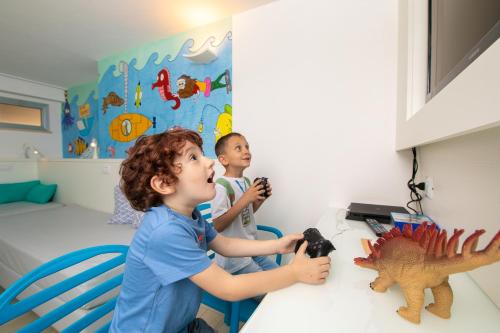 a young boy playing with a toy dinosaur in a room at Hotel Albatros in Rimini