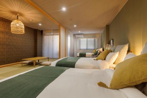 a hotel room with two beds and a table at Southerlies Condominium Onna in Onna