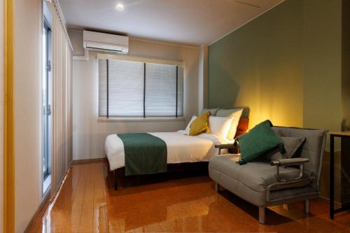a bedroom with a bed and a chair and a window at Southerlies Condominium Onna in Onna