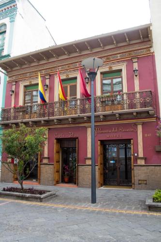a pink building with flags on a balcony at Morenica del Rosario in Cuenca