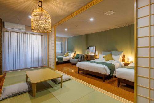 a bedroom with two beds and a living room at Southerlies Condominium Onna in Onna