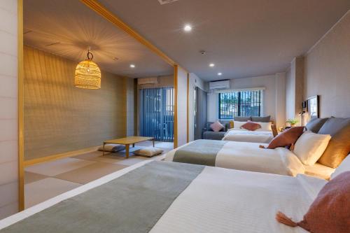 a hotel room with two beds and a table at Southerlies Condominium Onna in Onna