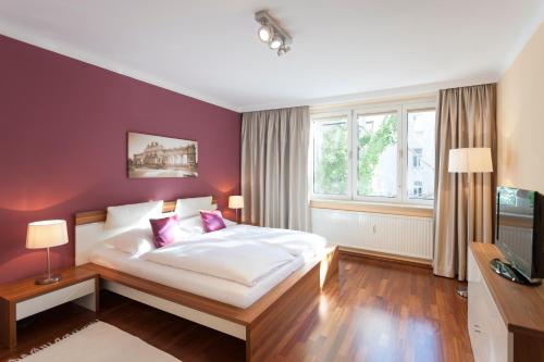 a bedroom with a white bed and a purple wall at im 2ten Business Apartments in Vienna