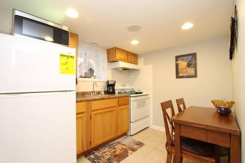 a kitchen with a table and a white refrigerator at 15 min Ohare/Rivers Casino/Downtown & Parking1 in Chicago