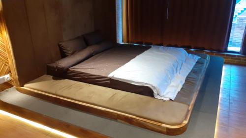 ein kleines Bett in einem Zimmer mit Fenster in der Unterkunft Dafano Villa in Sembalun Lawang