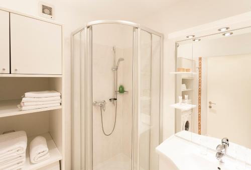 ein Bad mit einer Dusche und einem Waschbecken in der Unterkunft im 2ten Business Apartments in Wien