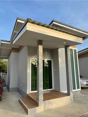a small house with a porch in a driveway at Araya Cottage in Ban Bung Thap Tae (1)
